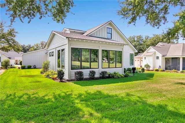 back of house with a lawn and a sunroom