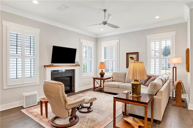 living room with crown molding, a fireplace, dark hardwood / wood-style floors, and ceiling fan