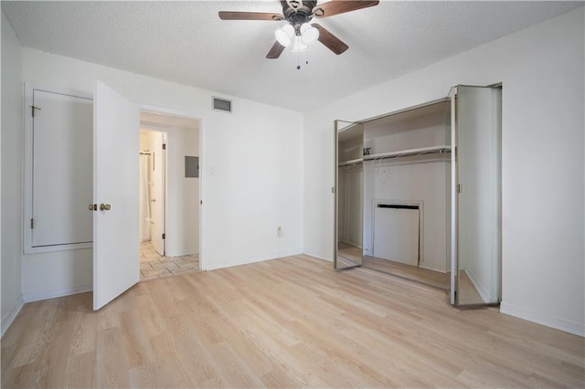 unfurnished bedroom with visible vents, ceiling fan, light wood-style floors, a closet, and a textured ceiling