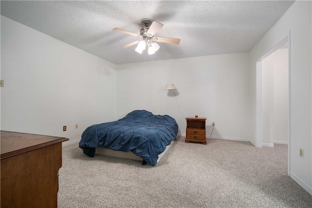 carpeted bedroom featuring a textured ceiling, baseboards, and a ceiling fan