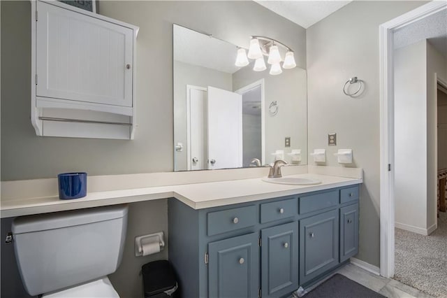 bathroom with baseboards, a notable chandelier, and vanity