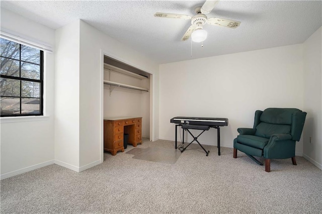 sitting room featuring carpet flooring, a ceiling fan, baseboards, and a textured ceiling