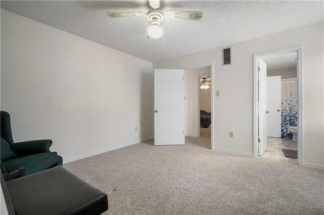 sitting room with baseboards, visible vents, carpet floors, ceiling fan, and a textured ceiling