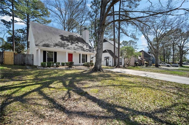 cape cod house with a front lawn, fence, and a chimney