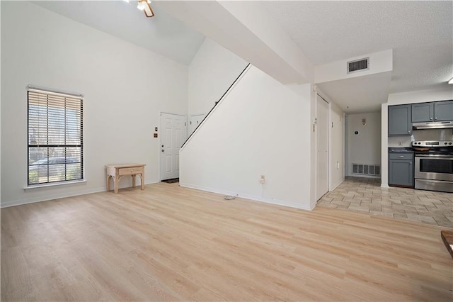 unfurnished living room with baseboards, visible vents, and light wood-type flooring