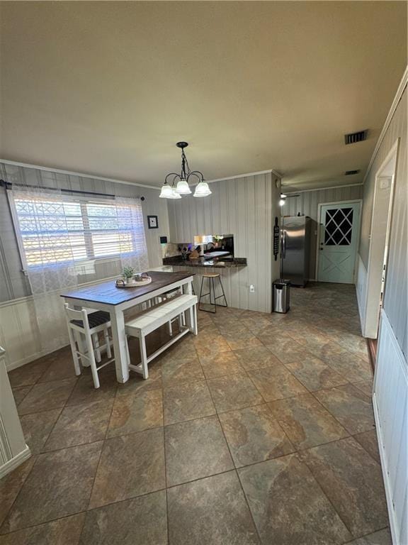 dining area with crown molding and an inviting chandelier