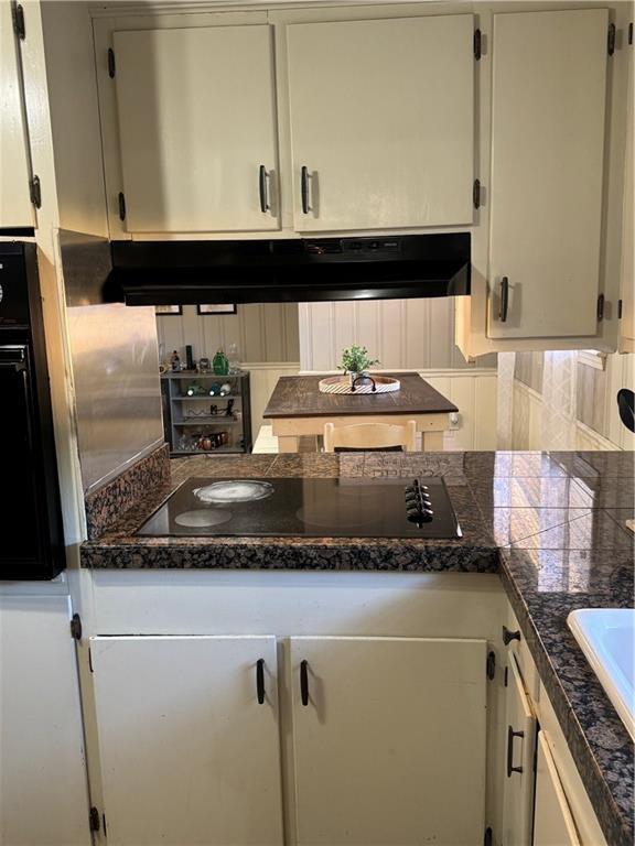 kitchen featuring black appliances, white cabinetry, and sink