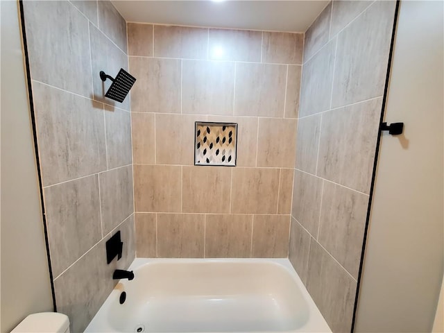 bathroom featuring toilet and tiled shower / bath combo