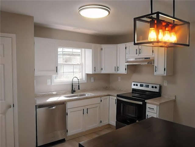 kitchen featuring sink, pendant lighting, light wood-type flooring, white cabinetry, and appliances with stainless steel finishes