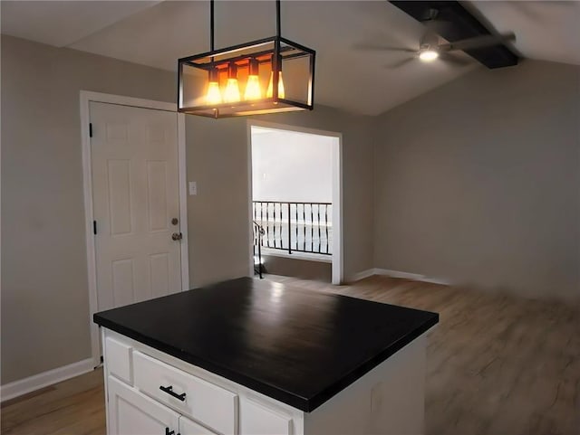 kitchen with vaulted ceiling, decorative light fixtures, light wood-type flooring, and white cabinets