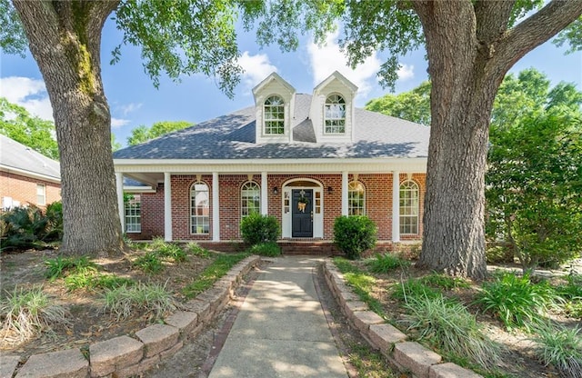 view of front of home featuring brick siding and a shingled roof
