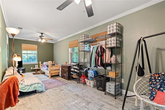 bedroom featuring hardwood / wood-style flooring, ceiling fan, and crown molding