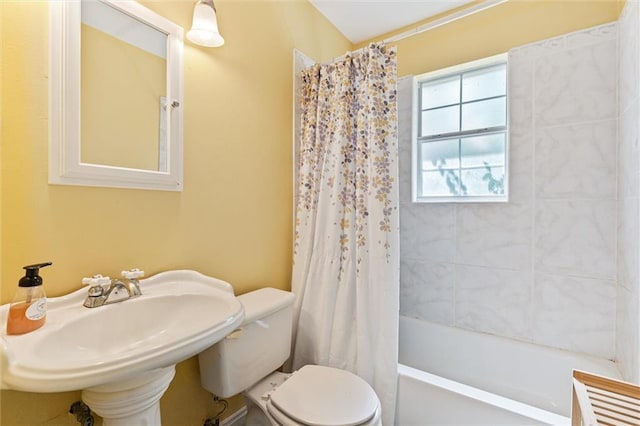 full bathroom featuring sink, shower / bathtub combination with curtain, and toilet