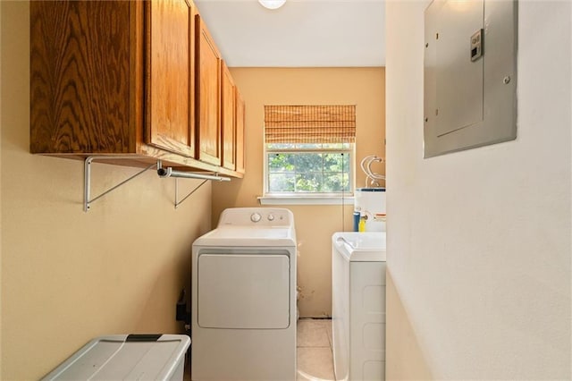 clothes washing area with cabinets, electric panel, electric water heater, and washing machine and clothes dryer