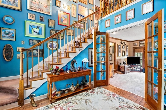 3425 Poe Rd S, Chunchula, AL 36521 - stairway featuring french doors, ornamental molding, and wood finished floors