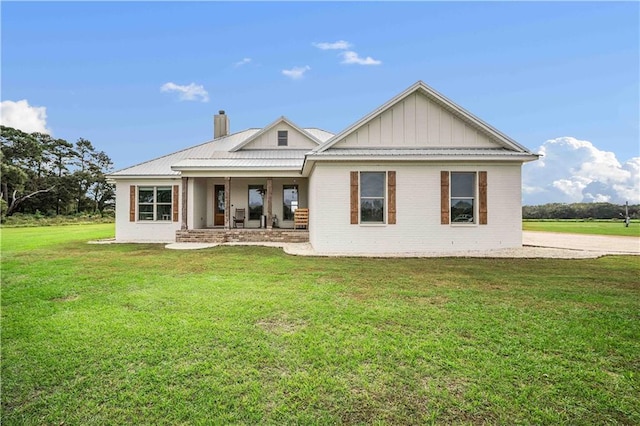 11531 Schmidt Ln S, Mobile, AL 36695 - back of house featuring covered porch, a lawn, brick siding, a chimney, and board and batten siding