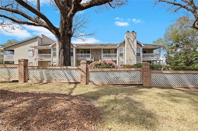 rear view of property featuring a chimney and fence