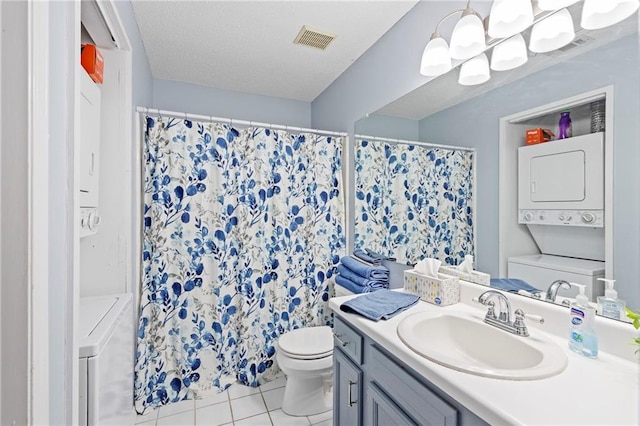 full bathroom with visible vents, toilet, stacked washer and clothes dryer, tile patterned floors, and vanity