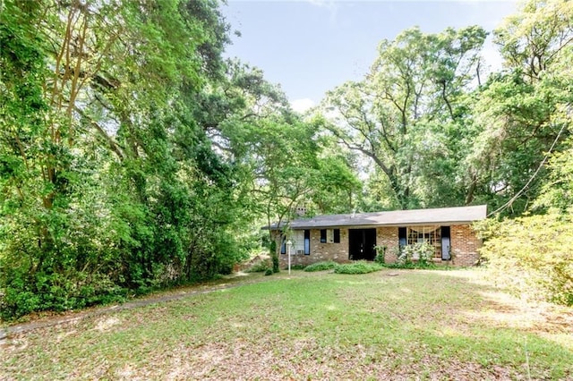 view of front of home with brick siding and a front yard