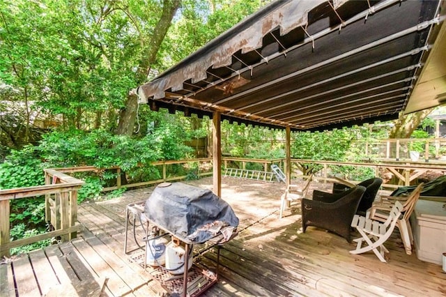 wooden deck featuring a grill and an outdoor fire pit