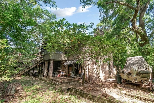 rear view of house featuring stairway and a deck