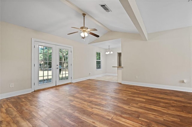 unfurnished living room with plenty of natural light, lofted ceiling with beams, ceiling fan with notable chandelier, and hardwood / wood-style flooring