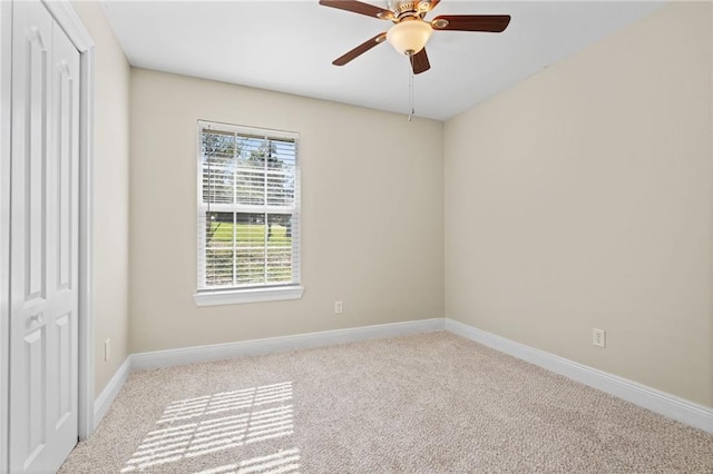 empty room featuring light colored carpet and ceiling fan