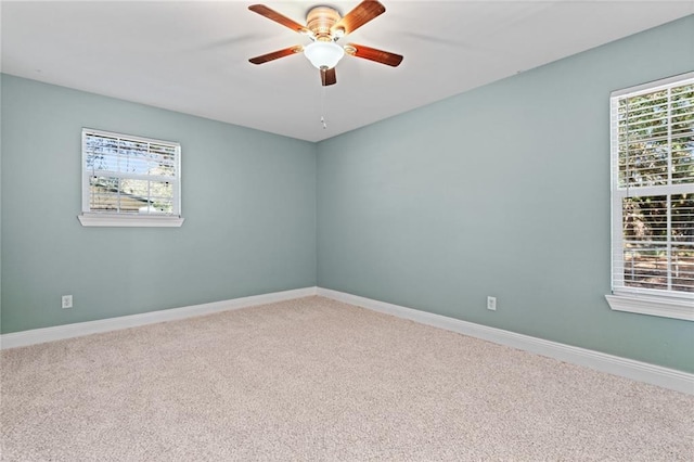 carpeted spare room with ceiling fan and a healthy amount of sunlight