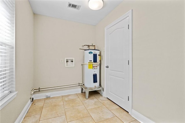 interior space featuring light tile patterned floors, hookup for a washing machine, and water heater