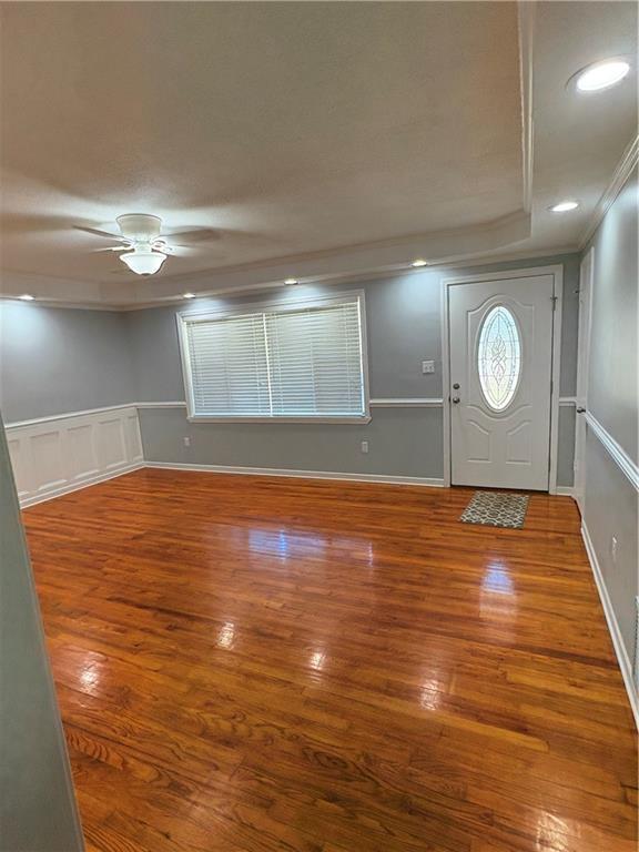 foyer entrance with hardwood / wood-style floors, crown molding, and ceiling fan