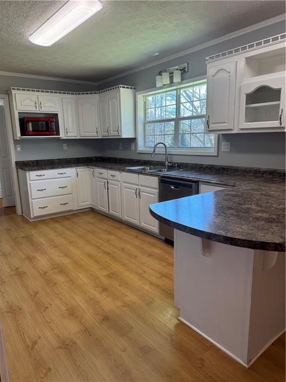 kitchen with white cabinetry, dishwasher, sink, and crown molding