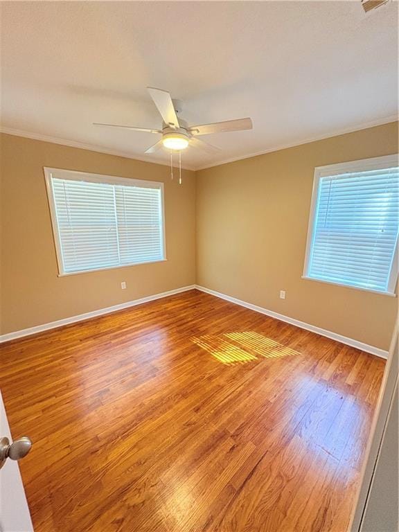 spare room featuring hardwood / wood-style floors, ornamental molding, and ceiling fan