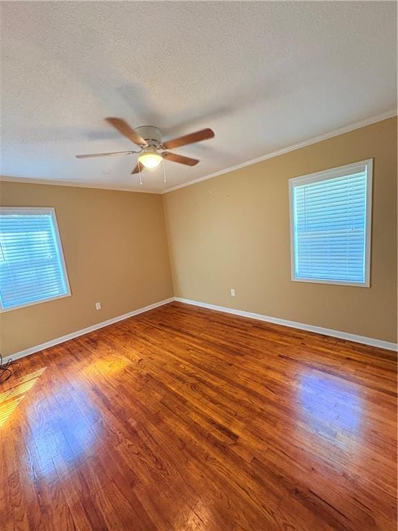 spare room featuring hardwood / wood-style floors, ornamental molding, a textured ceiling, and ceiling fan