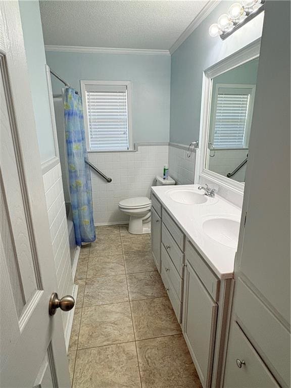 full bathroom featuring tile walls, vanity, ornamental molding, toilet, and a textured ceiling