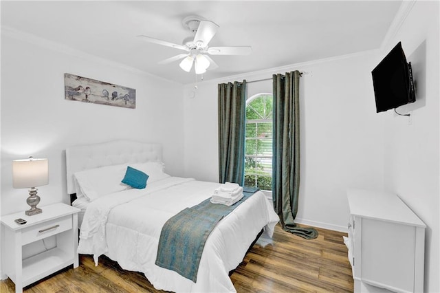 bedroom featuring wood finished floors, crown molding, baseboards, and ceiling fan