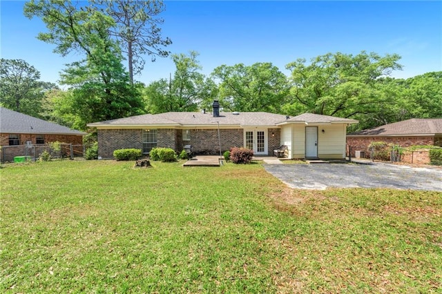 back of house featuring a lawn, fence, a patio area, and french doors