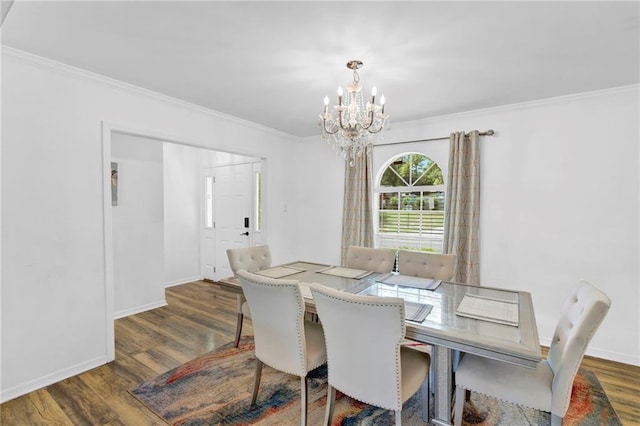 dining room with wood finished floors, baseboards, ornamental molding, and an inviting chandelier