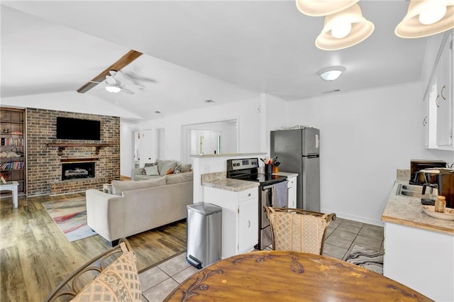 kitchen featuring a ceiling fan, a sink, stainless steel appliances, light countertops, and white cabinetry