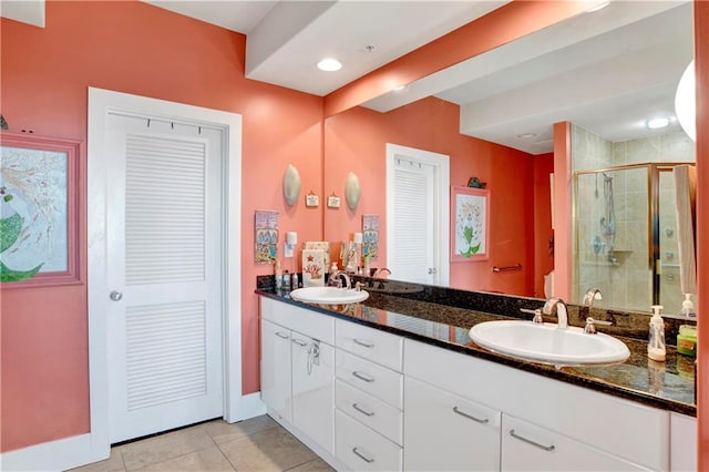 bathroom featuring vanity, tile patterned floors, and a shower with door