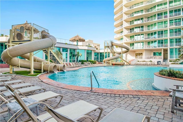 view of swimming pool with a patio and a water slide