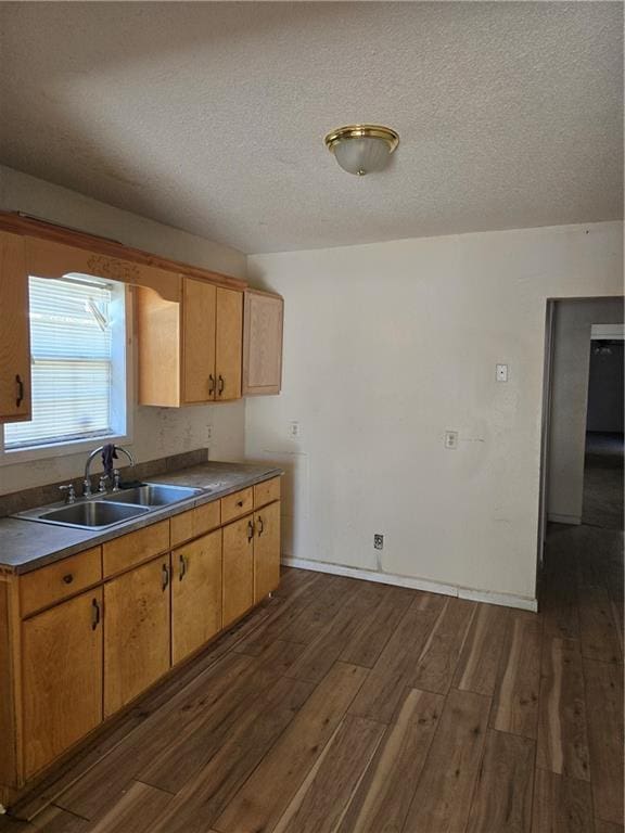 724 Half Ave, Mobile, AL 36610 - kitchen with dark wood-type flooring, baseboards, a textured ceiling, a sink, and dark countertops
