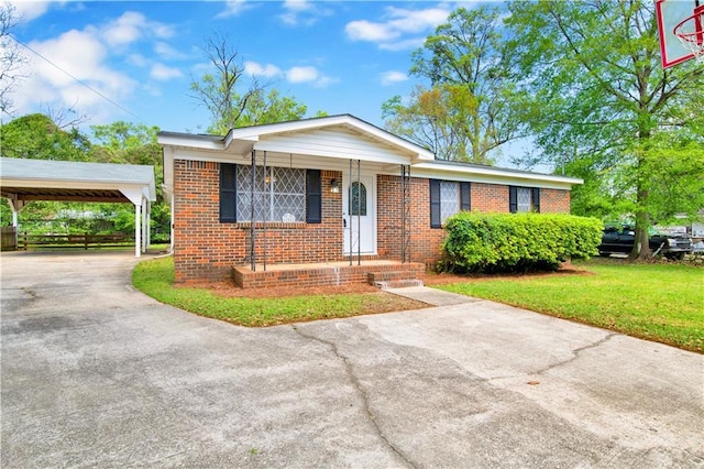 view of front facade with brick siding, a front lawn, concrete driveway, and a carport