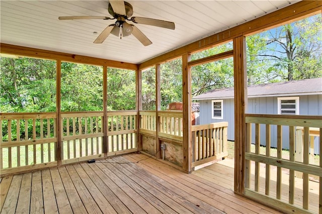 unfurnished sunroom featuring a ceiling fan and plenty of natural light