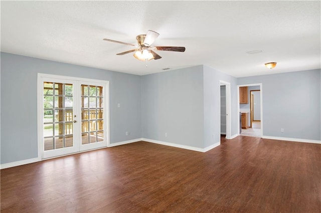 spare room featuring french doors, a ceiling fan, dark wood-style flooring, and baseboards