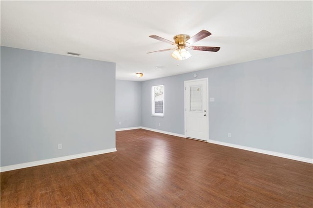 unfurnished room with baseboards, visible vents, wood finished floors, and a ceiling fan