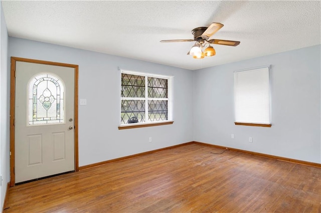 entrance foyer featuring baseboards, a textured ceiling, wood finished floors, and ceiling fan