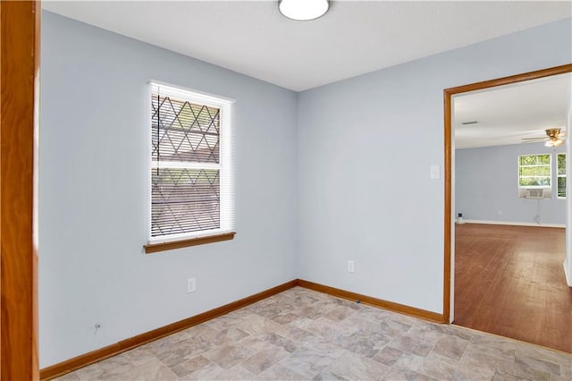 unfurnished room featuring baseboards and ceiling fan