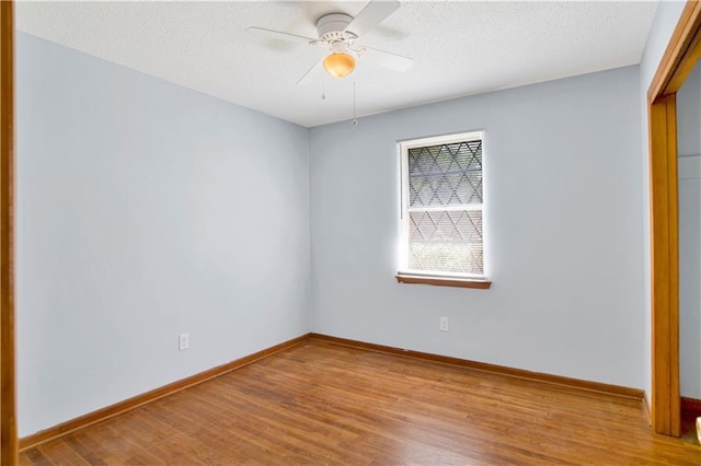 empty room featuring baseboards, a textured ceiling, ceiling fan, and wood finished floors