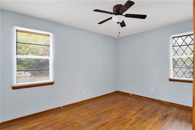 empty room with baseboards, ceiling fan, and wood finished floors