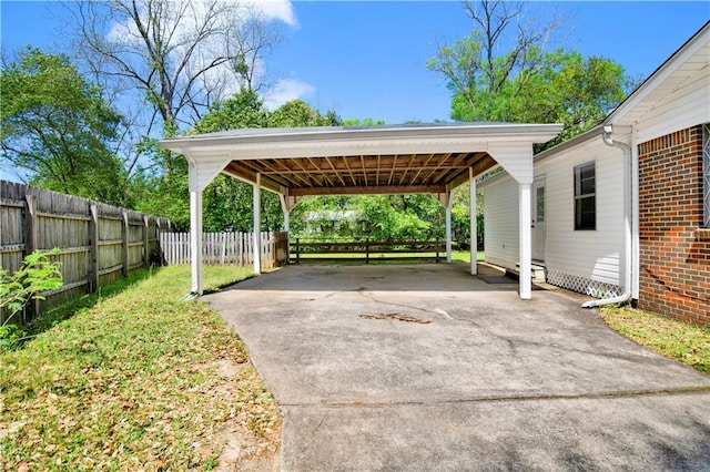 view of car parking with fence and concrete driveway